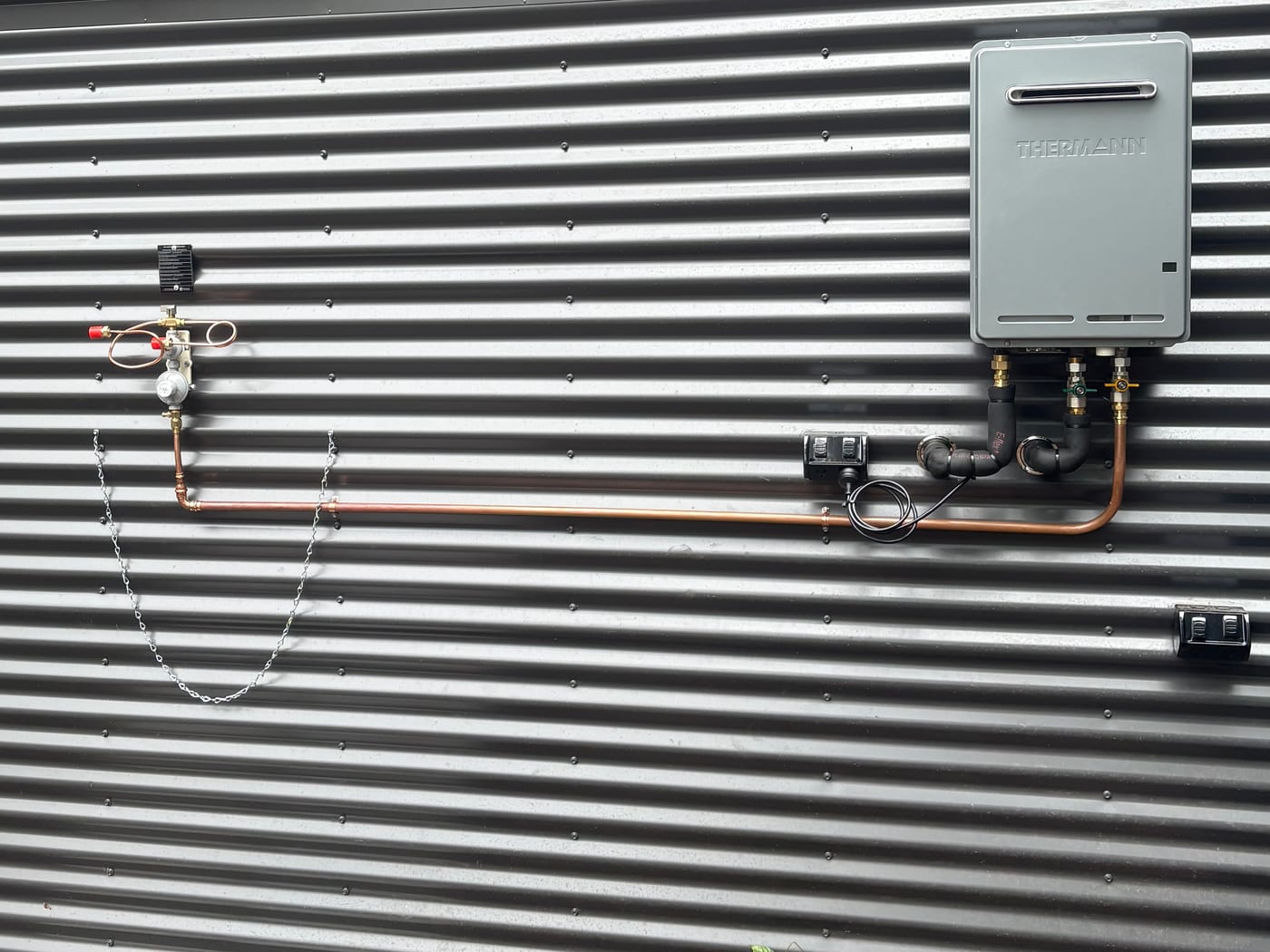 Thermann gas continuous-flow unit with LPG regulator and copper gas run on corrugated iron