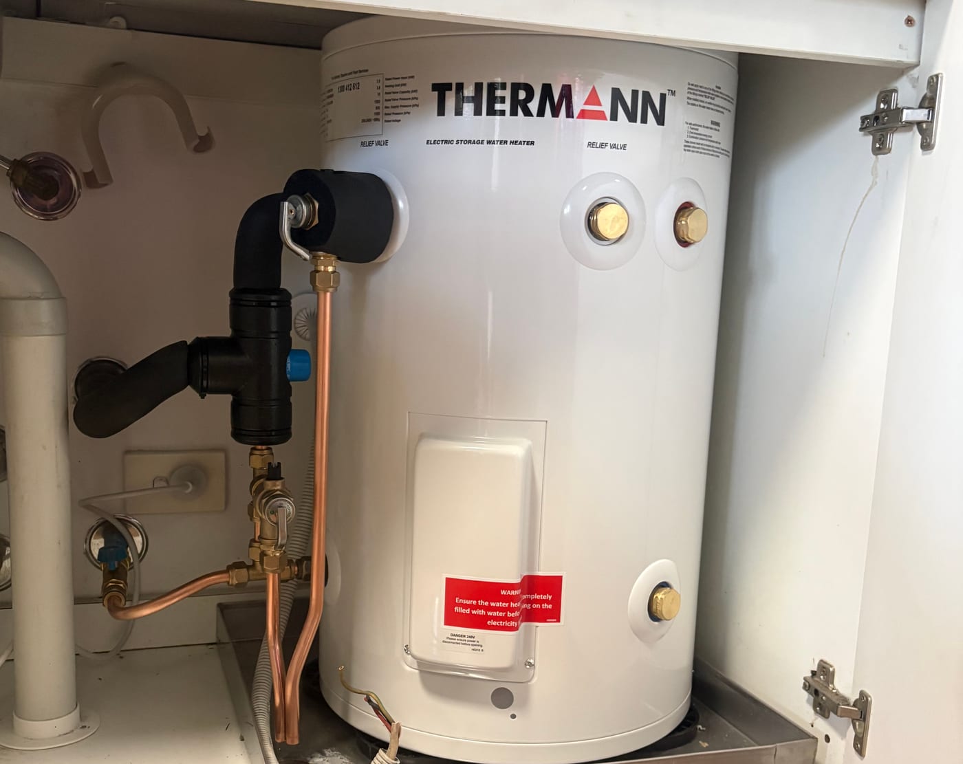 Thermann electric storage hot water cylinder with copper and lagged pipework, installed under a bench