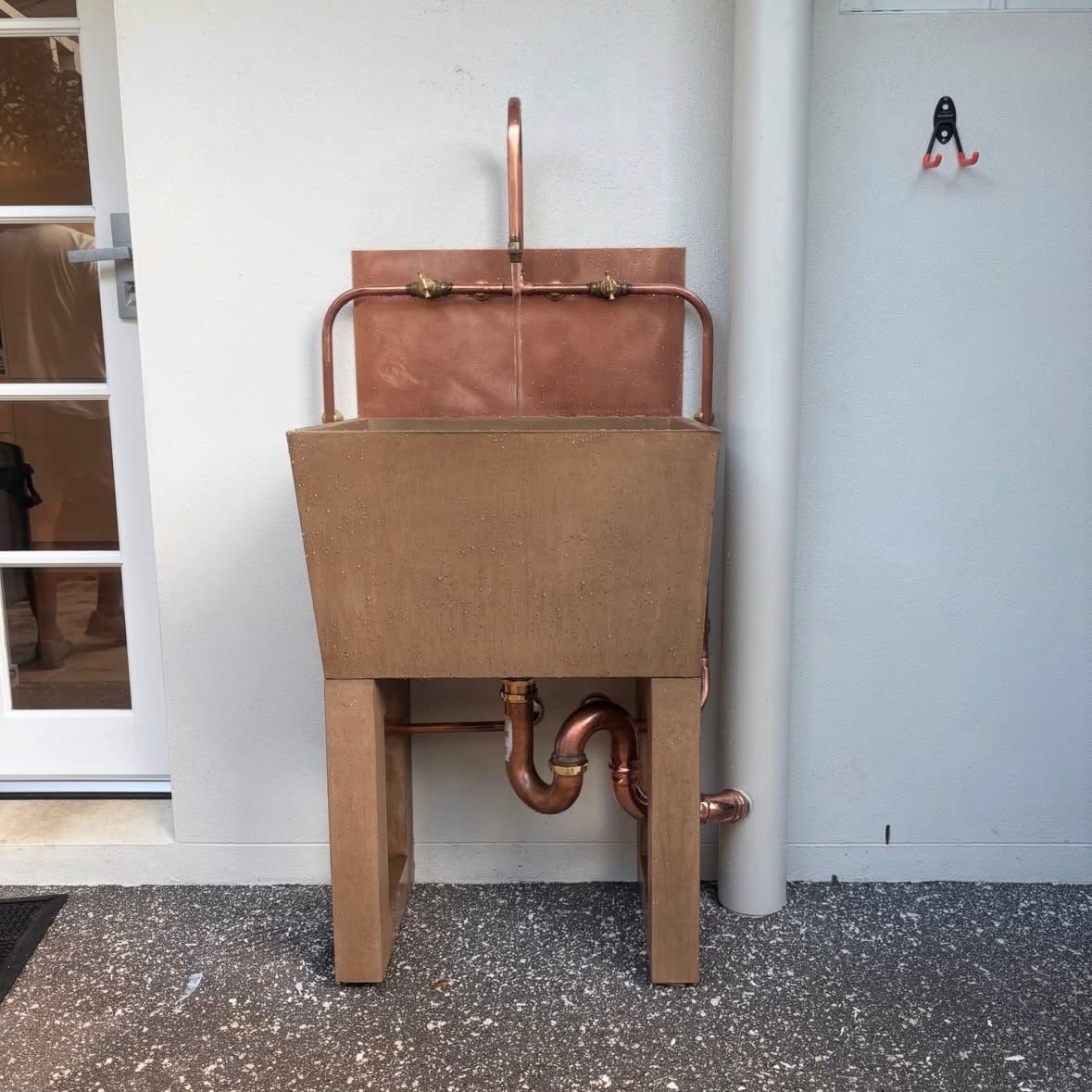 Outdoor copper sink with exposed copper tapware and trap